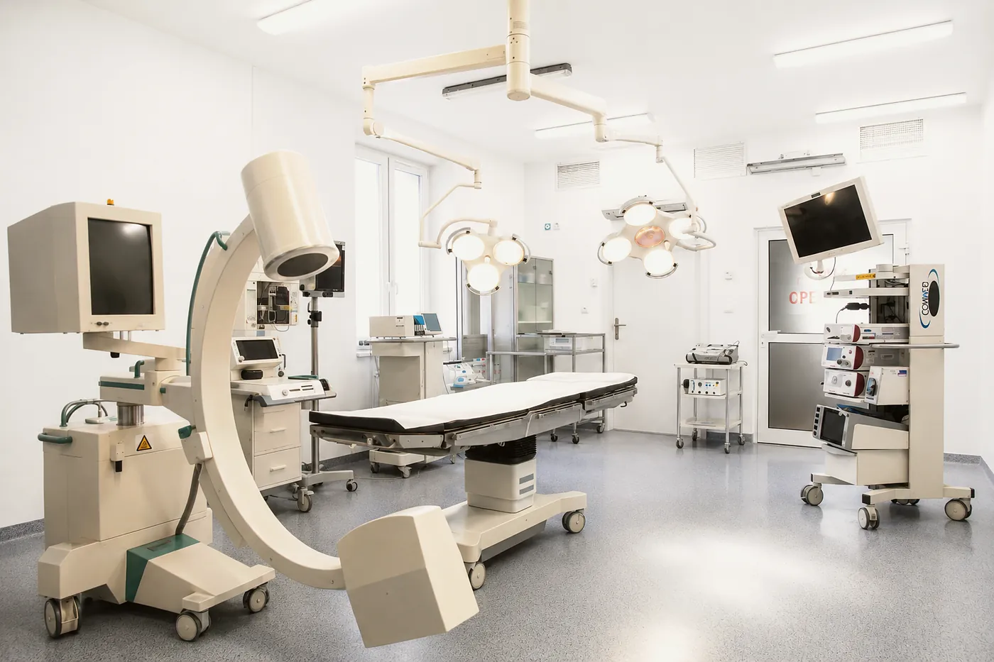 Sala operacyjna multiMEDICA — stół zabiegowy pod dwiema lampami bezcieniowymi.